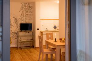una cucina e una sala da pranzo con tavolo e TV di Art Apartment Schatzer a Funes