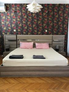 a bedroom with a large bed with pink pillows at Square Vanilla Downtown in Skopje