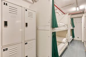 a room with bunk beds and green curtains at Hola Hostal Collblanc in Hospitalet de Llobregat