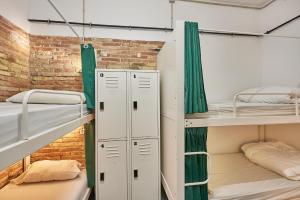 ロスピタレート・デ・リョブレガートにあるHola Hostal Collblancのレンガの壁の客室で、二段ベッド2組が備わります。