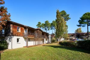 un bâtiment avec une terrasse sur son côté dans l'établissement Les Cottages Du Lac, à Parentis-en-Born