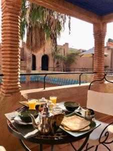 a table with a tea set on a patio with a view at Riad Zahir in Marrakech