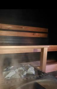 a grill with rocks in front of a wooden bench at Villa Latvus in Rovaniemi +39 photos
