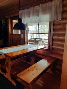 mesa de comedor y banco en una cabaña de madera en Villa Latvus, en Rovaniemi