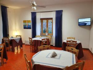 restauracja ze stołami i krzesłami oraz wentylatorem sufitowym w obiekcie Hotel Cormorano w mieście Pedaso