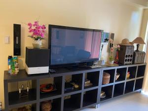 a television sitting on top of a entertainment center at Pico de Loro 2BR Vacation Flat in Nasugbu