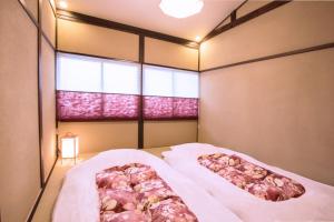 um quarto com 2 camas e uma janela em Rinn Rokujo Machiya em Quioto