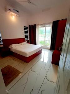 a bedroom with a bed and a large window at Rockdale Resort in Nilambūr