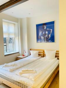 1 cama grande en un dormitorio con una foto en la pared en aday - Central cozy and bright apartment, en Aalborg