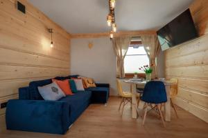 a living room with a blue couch and a table at Willa w Gliczarowie in Gliczarów