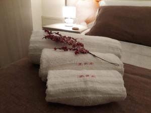 a pile of towels sitting on top of a bed at La Petite Maison in Aci Castello