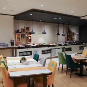 a kitchen with a table, chairs and a refrigerator at Holiday Inn Ankara-Kavaklidere, an IHG Hotel in Ankara