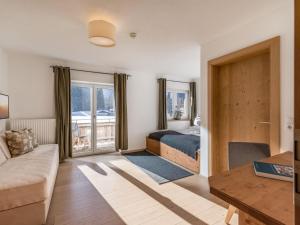 a bedroom with a bed and a couch and a table at Haus am Feld in Kitzbühel