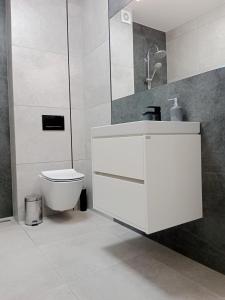 łazienka z białą umywalką i toaletą w obiekcie Apartamenty Radom Klwatecka 20 w Radomiu