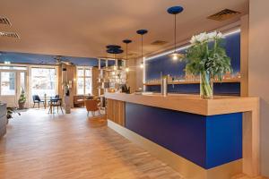 a bar with blue walls and a vase of flowers at Pension Zeitlos in Potsdam