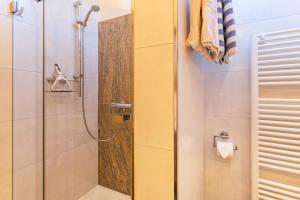 La salle de bains est pourvue d'une douche avec une porte en verre. dans l'établissement Ferienwohnung Bergkristall, à Mittenwald