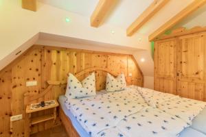 um quarto com uma cama e uma parede de madeira em Ferienwohnung Bergkristall em Mittenwald