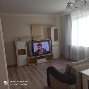 a living room with a flat screen tv on a entertainment center at Апартаменты на Московском проспекте in Kaliningrad
