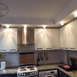 a kitchen with a stove and white cabinets at Апартаменты на Московском проспекте in Kaliningrad