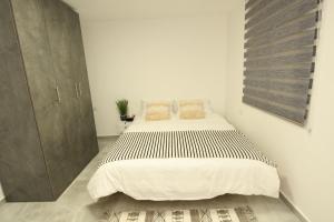 a white bedroom with a large bed in it at MAKAZA neviot in Eilat