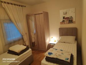 um pequeno quarto com uma cama e uma janela em Villa Lisinski em Zadar