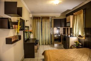 sozos inn hotel vonitsa في فونيتسا: غرفة مع مطبخ وسرير في غرفة