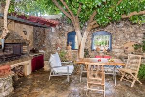 a kitchen with a table and chairs and a tree at Hekate House, bohemian country house, 4 bedrooms for 8 persons in Xirostérnion