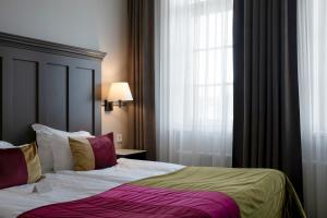 um quarto com uma cama e uma janela em Elite Stora Hotellet em Jönköping