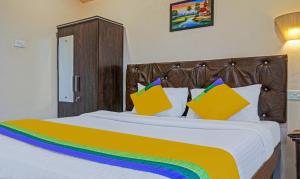 a large bed with colorful pillows on it at Itsy By Treebo - Punest in Pune