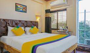 a bedroom with a large bed with colorful pillows at Itsy By Treebo - Punest in Pune