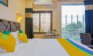 a hotel room with a bed and a large window at Itsy By Treebo - Punest in Pune