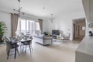 een woonkamer met een bank en een tafel en stoelen bij HiGuests - Artistic Apt with Balcony Overlooking Dubai Canal in Dubai