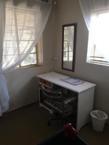a desk in a room with a mirror and windows at Bloekomhuis in Smithfield