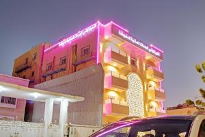 a pink building with a neon sign on it at Al Tamayoz Al Raqi - Bani Malik in Jeddah