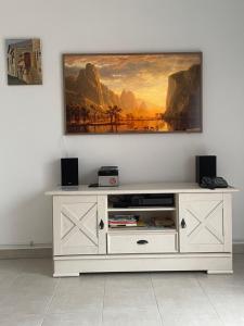 ein weißes Unterhaltungszentrum mit einem Gemälde an der Wand in der Unterkunft Villa Fior 50 in Santa-Maria-Poggio