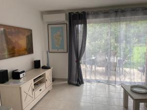 ein Wohnzimmer mit großem Fenster und Tisch in der Unterkunft Villa Fior 50 in Santa-Maria-Poggio