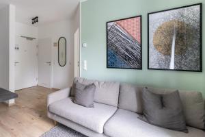 een woonkamer met een bank en twee foto's aan de muur bij limehome Linz Hopfengasse in Linz