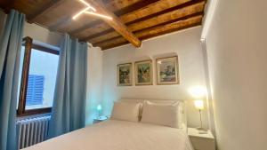 a bedroom with a white bed and a window at Chiasso degli Armati in Florence