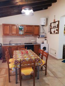 una cucina con tavolo, sedie e piano cottura di Casa vacanza L'antico moderno a Terrasini