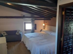 um quarto com 2 camas, um sofá e uma janela em Casas Recuero em Chinchón