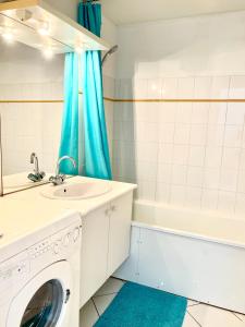 uma máquina de lavar roupa na casa de banho com um lavatório e uma banheira em COUP DE CŒUR - ILE DE RE - Maison 3 chambres em Rivedoux-Plage