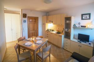 a kitchen and dining room with a table and chairs at Apartament DADAJ in Dadaj