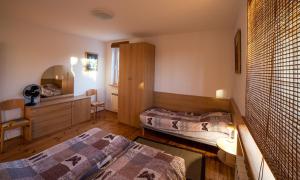 a bedroom with two beds and a desk and a mirror at Apartament DADAJ in Dadaj