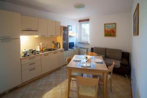 a kitchen and dining room with a table and a couch at Apartament DADAJ in Dadaj +2 photos