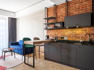 a kitchen with a table and a brick wall at Mercure Krakow Fabryczna City in Krakow