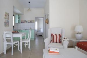 a living room with a chair and a table and a kitchen at Skopelos Summer Homes in Skopelos Town