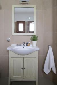 a bathroom with a white sink and a mirror at Skopelos Summer Homes in Skopelos Town