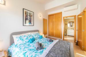 1 dormitorio con 1 cama grande con sábanas azules en MEDANO4YOU Barefoot Beach House en El Médano