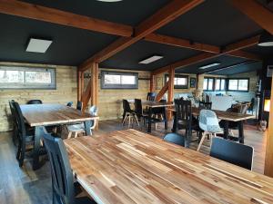 una sala da pranzo con tavoli e sedie in legno di Les Chalets Du Goulet a Le Bleymard