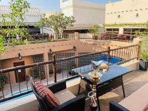 a patio with a table and chairs on a balcony at Al Liwan Suites in Doha